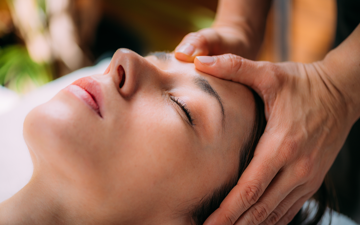 Person receiving a relaxing facial massage.